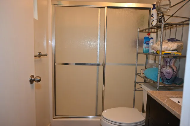 a bathroom with a sink a toilet and shower