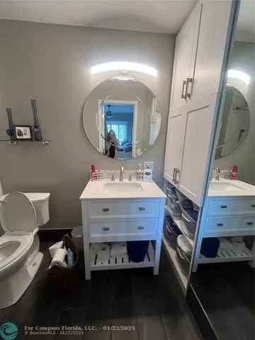 a bathroom with a sink mirror and toilet