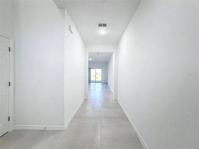 an empty room with entrance and windows