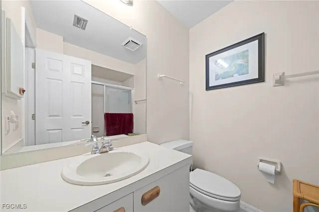 a bathroom with a toilet sink vanity and mirror