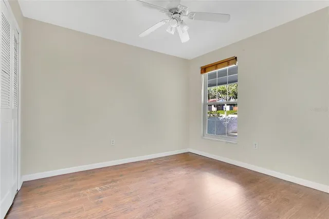 an empty room with windows and fan
