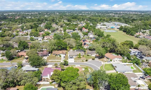 an aerial view of residential houses with outdoor space and trees