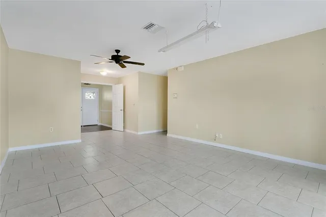 an empty room with a ceiling fan and carpet