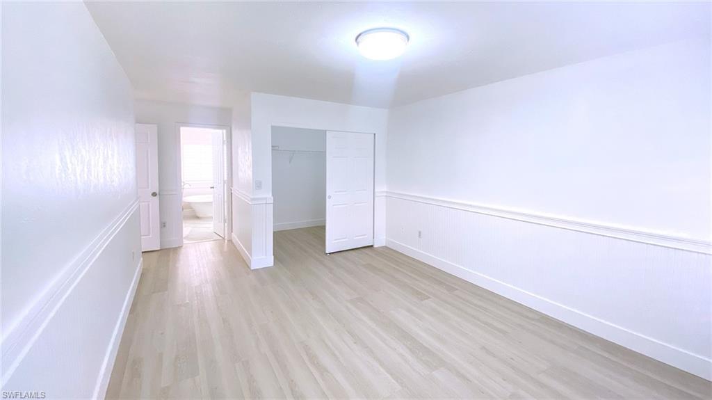 718 Reef Point Circle Naples, FL 34108 - Photo 14 of 23 a view of an empty room with wooden floor