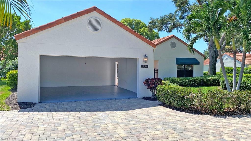 718 Reef Point Circle Naples, FL 34108 - Photo 17 of 23 a view of a white house with a yard and large tree