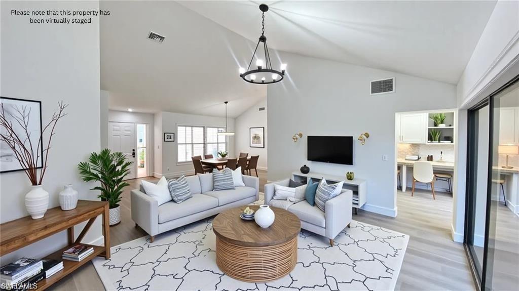 718 Reef Point Circle Naples, FL 34108 - Photo 2 of 23 a living room with furniture and a flat screen tv