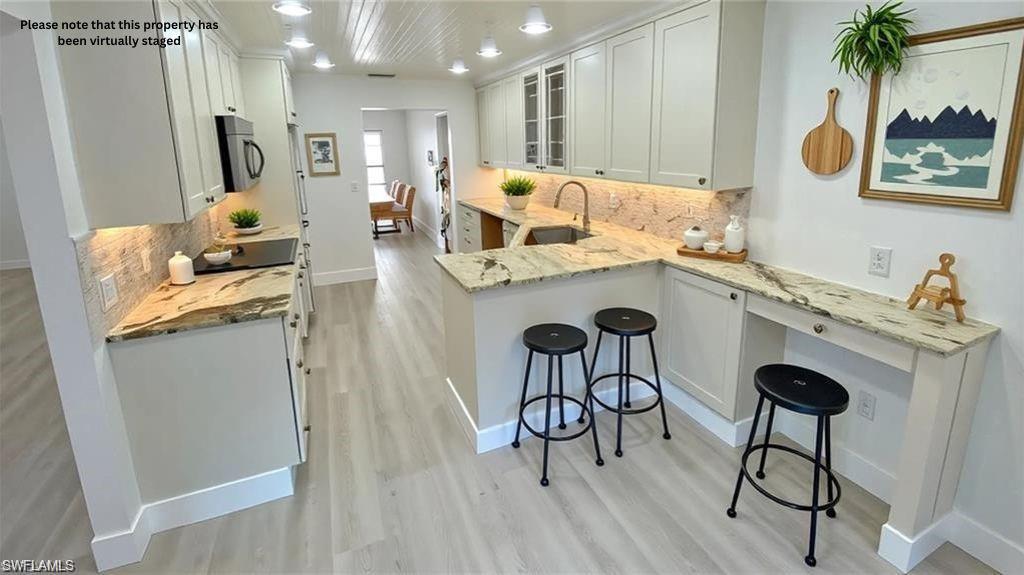 718 Reef Point Circle Naples, FL 34108 - Photo 3 of 23 a view of kitchen island with furniture and wooden floor