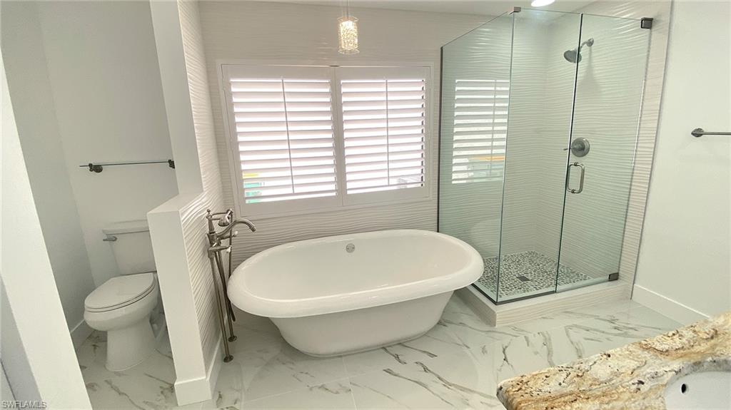 718 Reef Point Circle Naples, FL 34108 - Photo 5 of 23 a white bath tub sitting next to a toilet