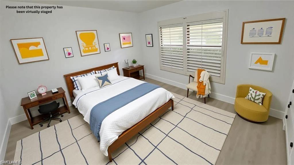 718 Reef Point Circle Naples, FL 34108 - Photo 6 of 23 a bedroom with a bed and wooden floor