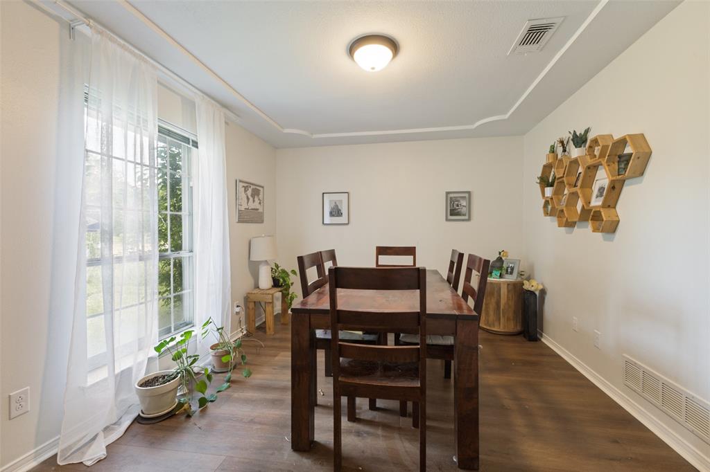 705 South Grove Road Richardson, TX 75081 - Photo 11 of 26 Spacious room featuring wood-finish flooring, a large window with natural light, and a tray ceiling detail