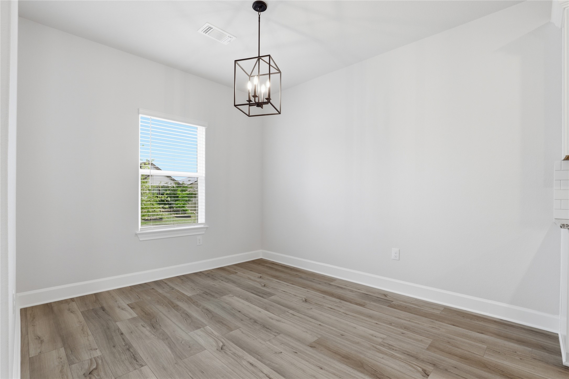 9320 Gladsome Path Manor, TX 78653 - Photo 7 of 34 an empty room with wooden floor and windows