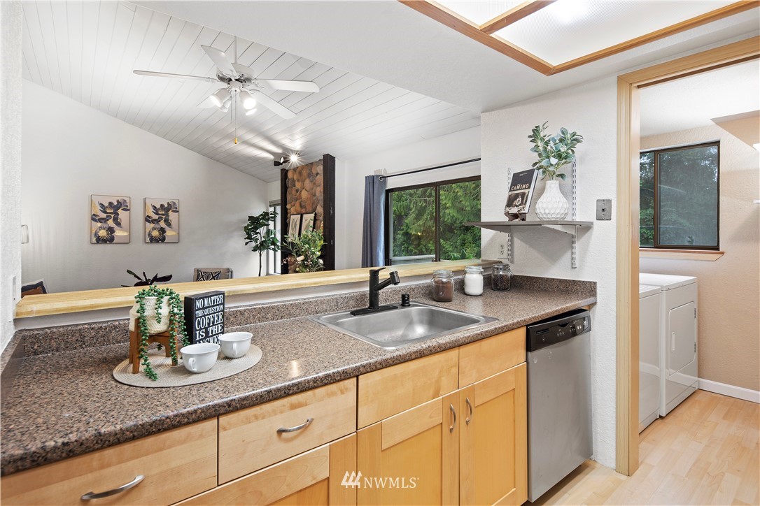 14401 Southeast Petrovitsky Road, Unit B204 Renton, WA 98058 - Photo 15 of 31 a kitchen with kitchen island granite countertop a sink stainless steel appliances and cabinets