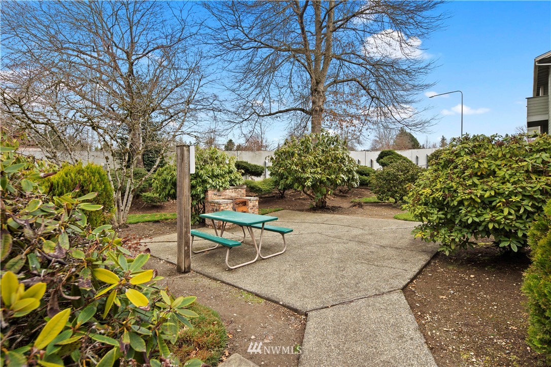 14401 Southeast Petrovitsky Road, Unit B204 Renton, WA 98058 - Photo 26 of 31 a garden with a bench and some trees