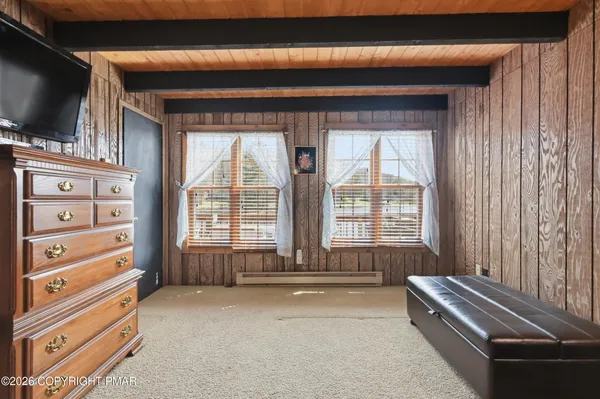 a view of a hallway with wooden floor and windows