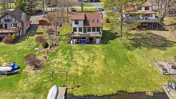 an aerial view of a house with a yard and lake view