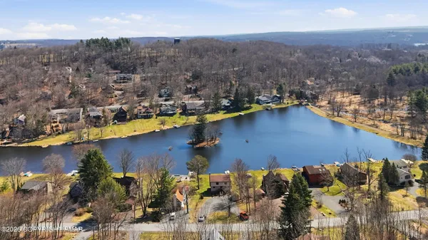an aerial view of a house with a yard and lake view
