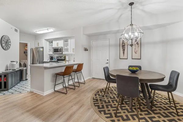 a dining room with furniture a chandelier and wooden floor