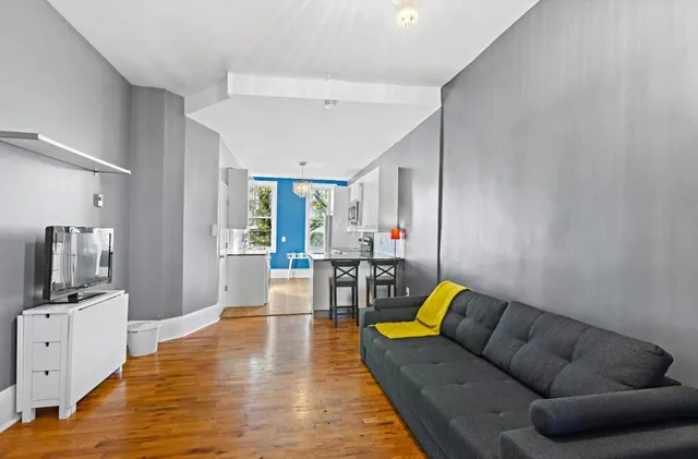 a living room with furniture and wooden floor