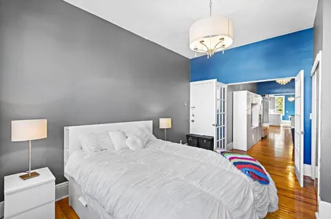 a bedroom with a bed and wooden floor