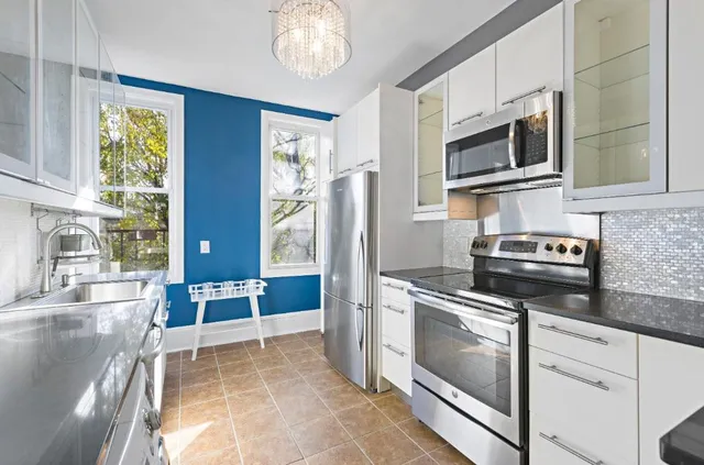 a kitchen with stainless steel appliances granite countertop a stove and a microwave
