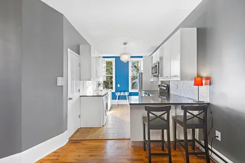 a dining room with stainless steel appliances a table and chairs