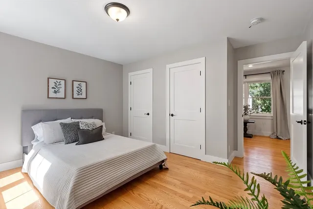 a bedroom with a bed and wooden floor