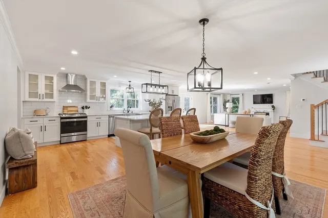 a view of a dining room and livingroom with furniture wooden floor a chandelier