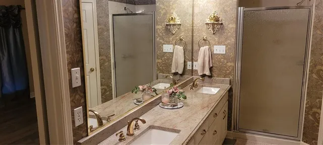 a bathroom with a sink vanity granite and shower