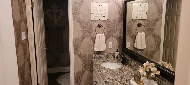 a bathroom with a granite countertop shower sink and mirror