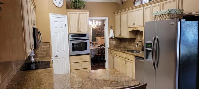 a kitchen with stainless steel appliances a refrigerator a stove and cabinets