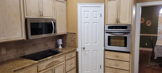 a kitchen with white cabinets and black appliances