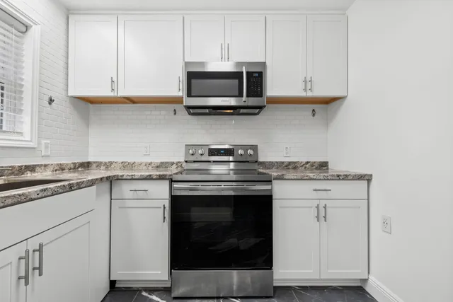 a kitchen with stainless steel appliances granite countertop a stove and a microwave