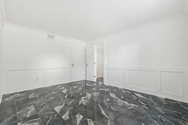 a spacious bathroom with a granite countertop sink a toilet and a mirror