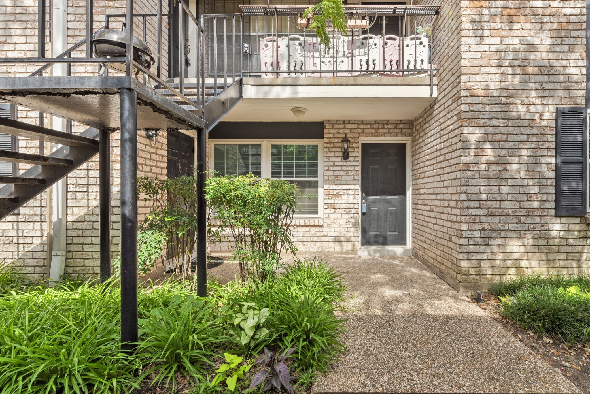 7900 Westheimer Road, Unit 121 Houston, TX 77063 - Photo 6 of 23 a front view of a house with a garden