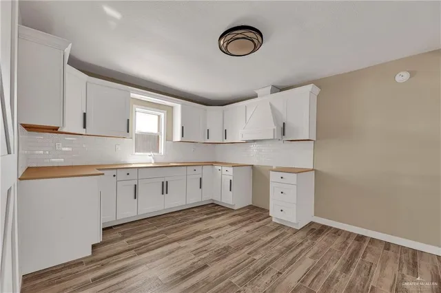 a kitchen with cabinets appliances and a wooden floor