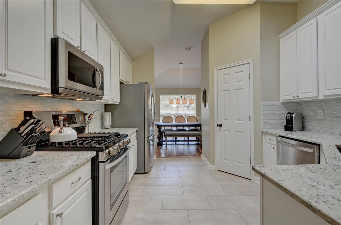 a kitchen with stainless steel appliances granite countertop a stove oven and a refrigerator