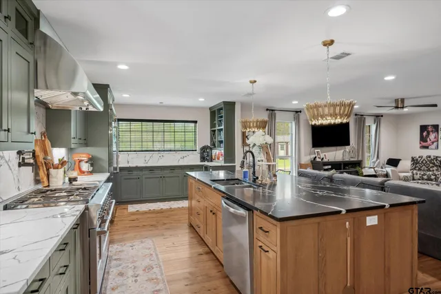 a kitchen with stainless steel appliances a sink stove and cabinets