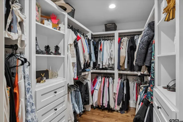 a view of walk in closet with clothes and shoes