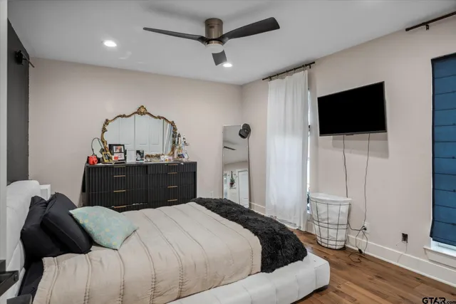 a bedroom with a bed a flat screen tv and a chandelier