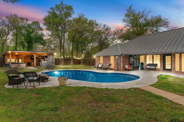 a view of house with swimming pool outdoor seating and green space