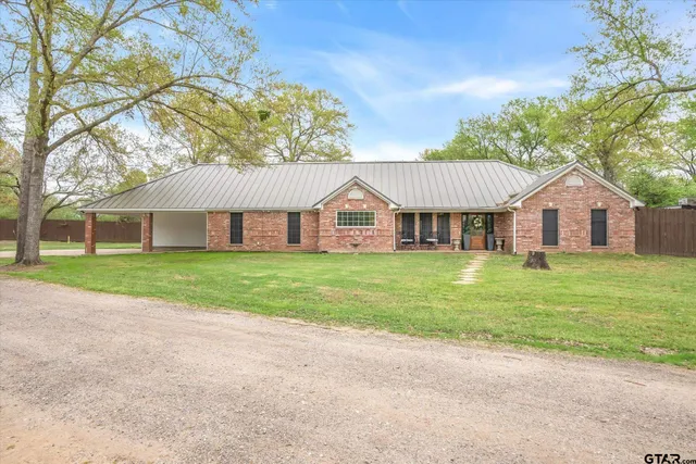 a view of a house next to a yard with large trees