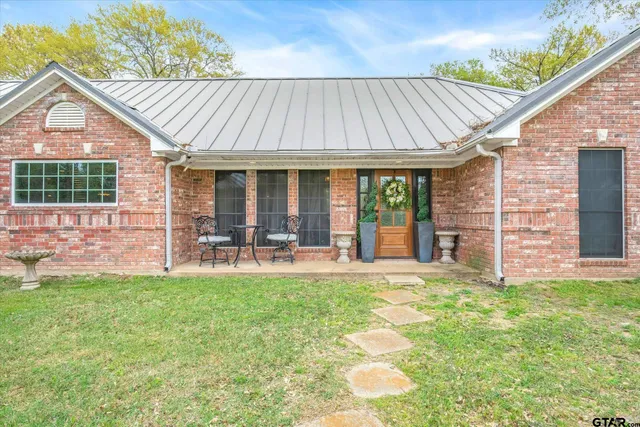 a view of a house with a backyard and a patio