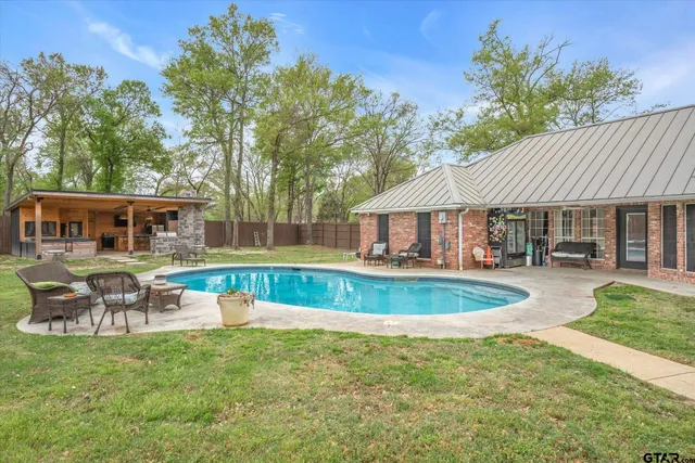 a front view of a house with swimming pool having outdoor seating