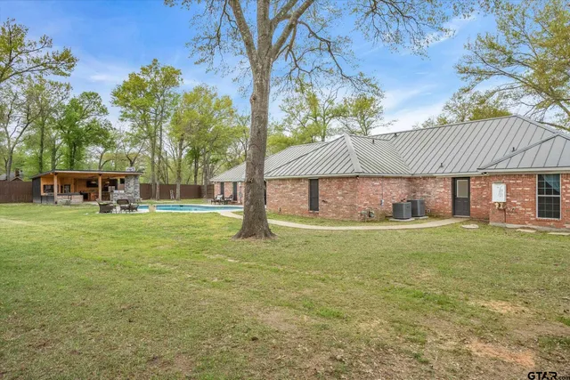 a view of a house with a yard and sitting area