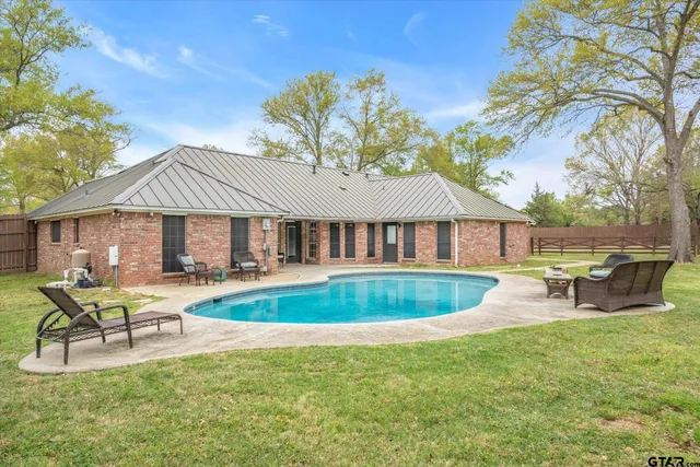a view of a house with swimming pool and sitting area