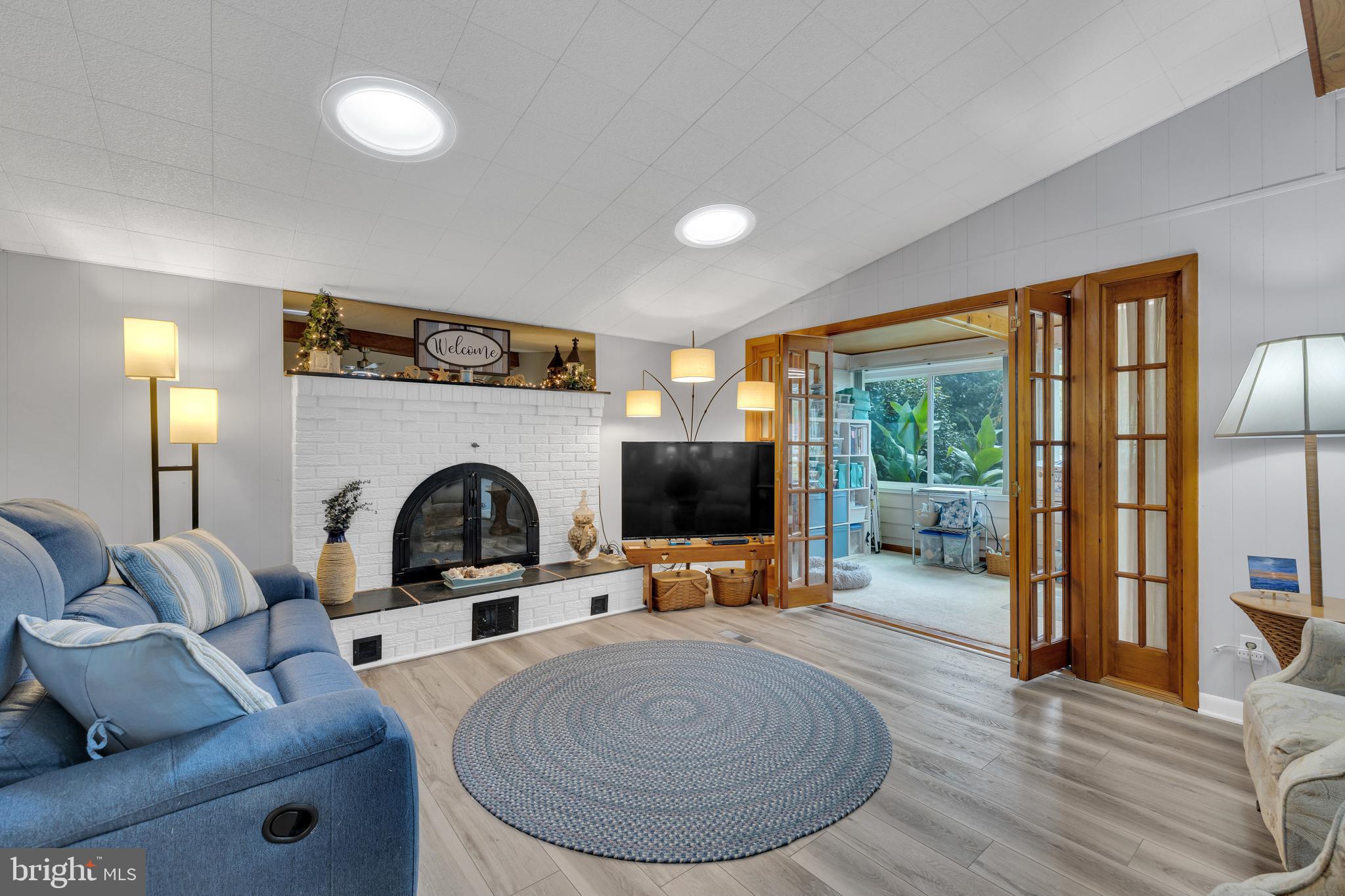 30879 Maplewood Road Ocean View, DE 19970 - Photo 11 of 41 a living room with furniture a fireplace and a flat screen tv