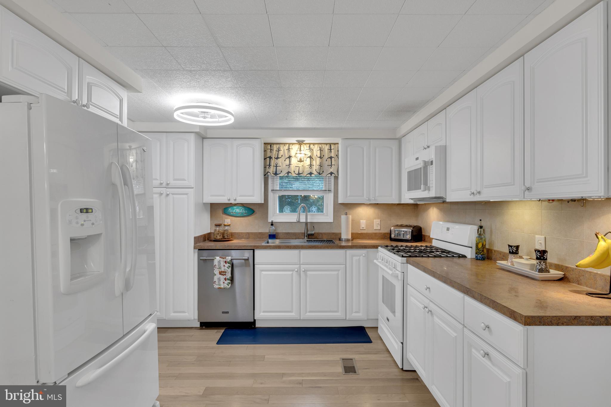 30879 Maplewood Road Ocean View, DE 19970 - Photo 19 of 41 a kitchen with stainless steel appliances granite countertop a sink stove and refrigerator