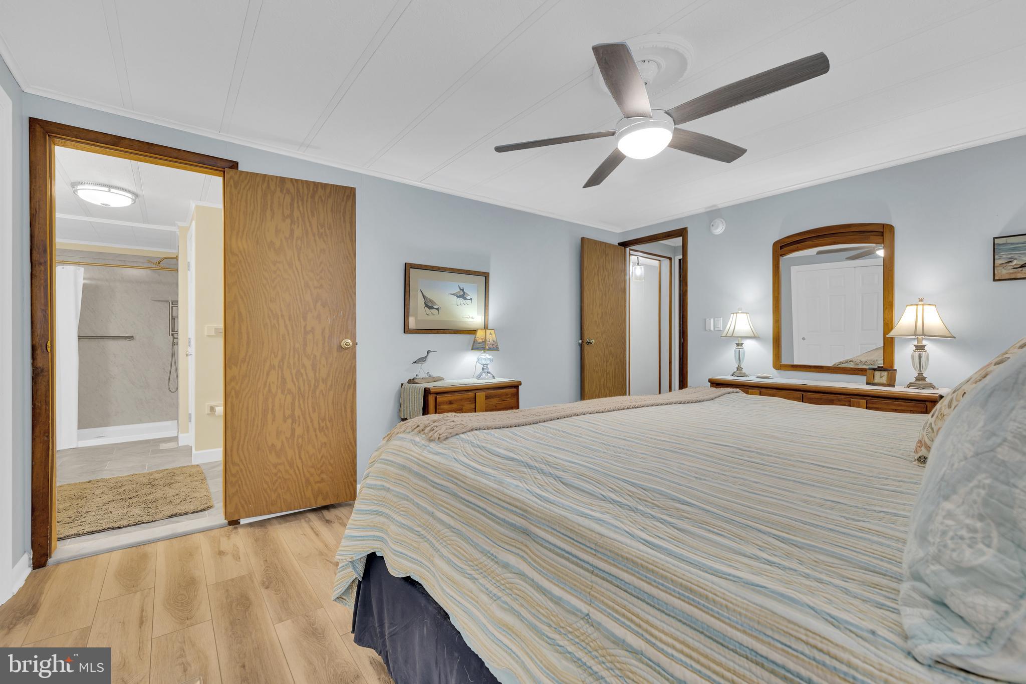 30879 Maplewood Road Ocean View, DE 19970 - Photo 27 of 41 a bedroom with a bed and a large mirror with a flat tv screen