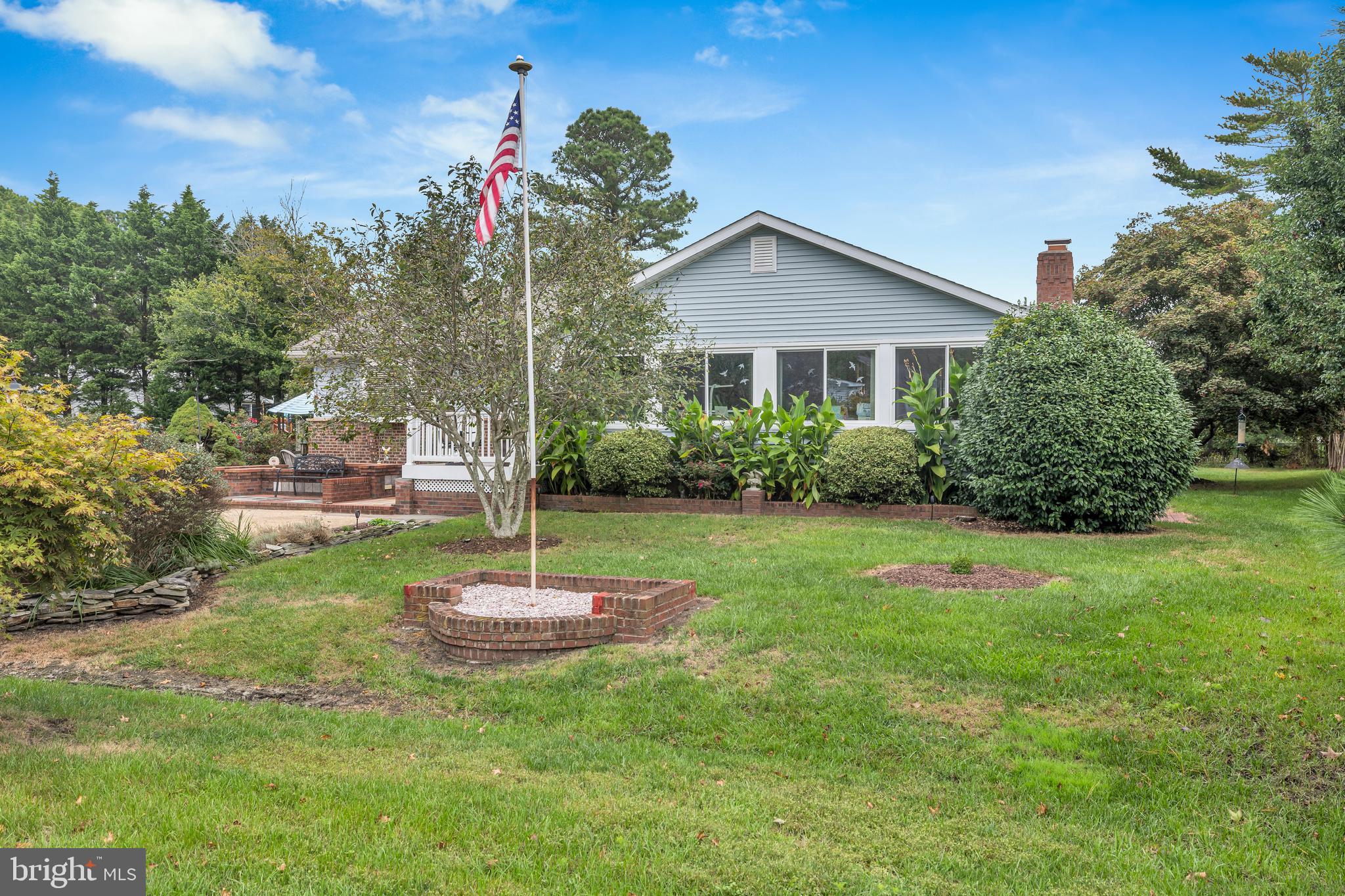 30879 Maplewood Road Ocean View, DE 19970 - Photo 3 of 41 a front view of a house with a yard and potted plants