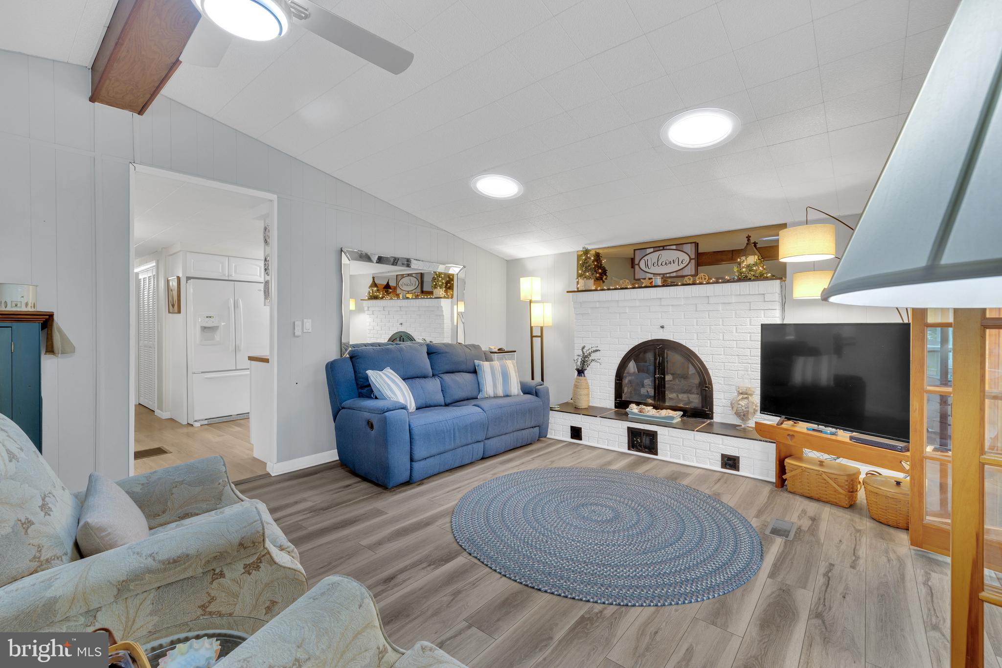 30879 Maplewood Road Ocean View, DE 19970 - Photo 10 of 41 a living room with furniture a flat screen tv and a fireplace